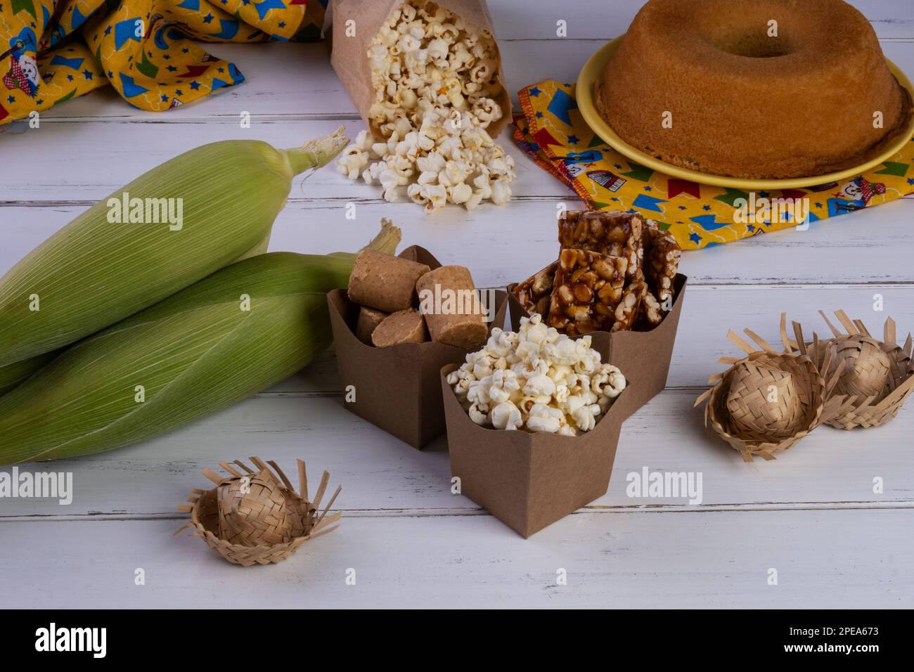 mais verde e dolci di festa junina su tavola di legno bianco. Foto Stock