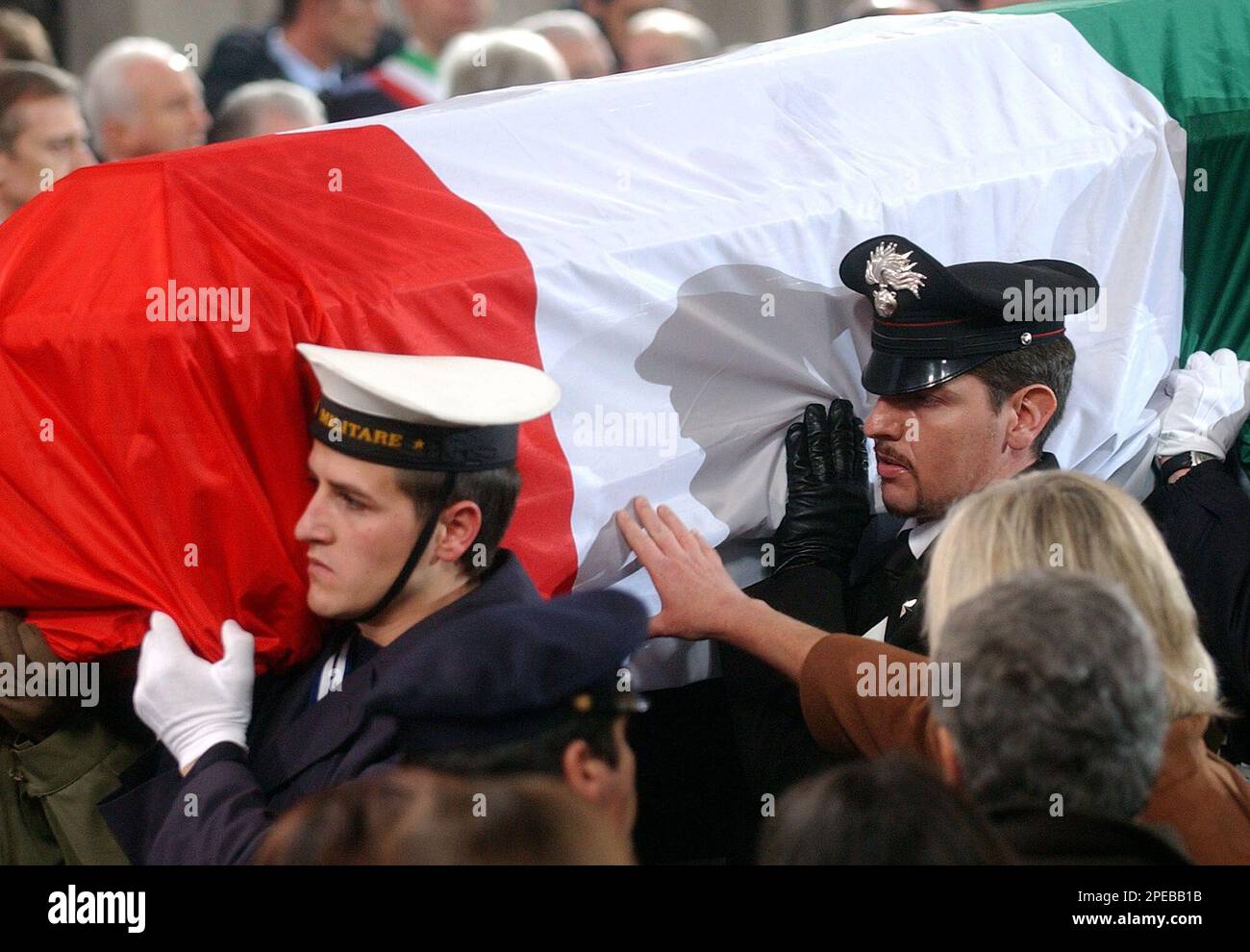 A hand reaches for the coffin containing the body of late Italian intelligence officer Nicola Calipari during his State funerals in Rome, Monday, March 7, 2005. Calipari was killed in controversial circumstances when an US armored vehicle opened fire on the car he was traveling in with just fred Italian hostage, journalist Giuliana Sgrena on Friday. (AP Photo/Plinio Lepri) Foto Stock