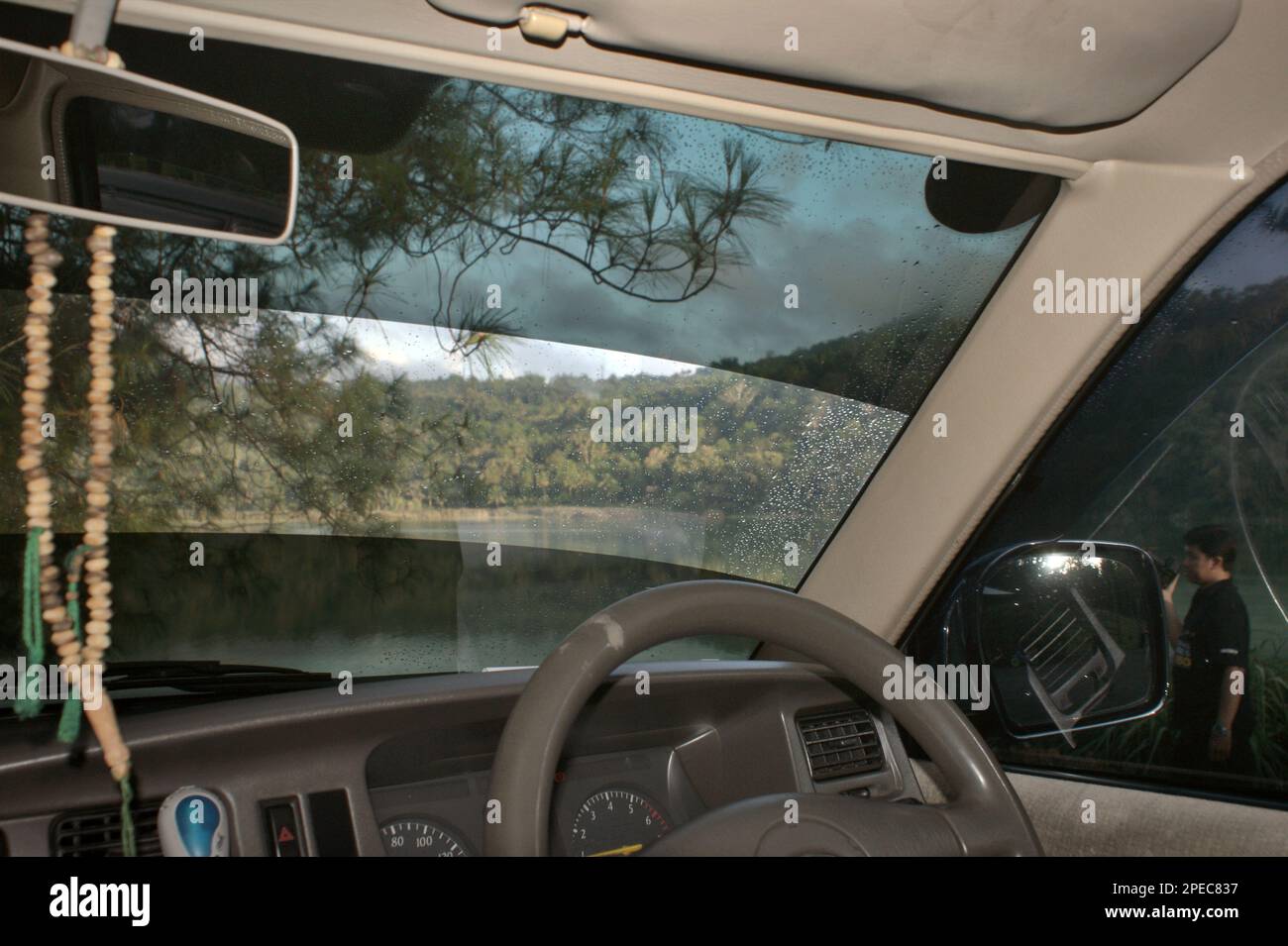 L'interno di un'auto è fotografato in uno sfondo di uno scenario del lago Linow, un lago vulcanico a Lahendong, Tomohon Sud, Tomohon, Sulawesi Nord, Indonesia. Foto Stock