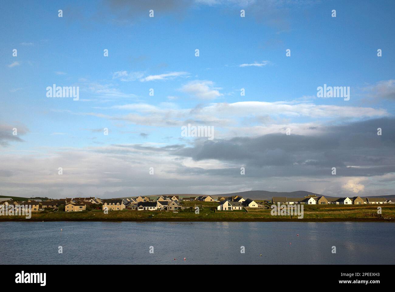 Fotografia a colori di un fiume, case e campi, Stromness, Isole Orcadi, Scozia, Regno Unito, 2022. Foto Stock