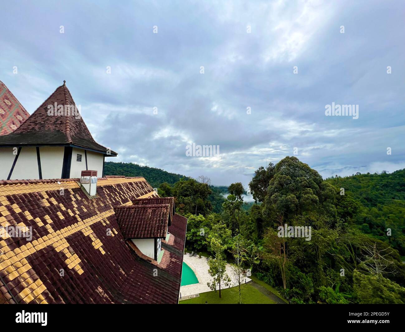 Colmar tropicale, Malesia. 02nd Mar, 2023. Vista su uno dei tetti spioventi di Colmar Tropicale a strisce di nebbia sopra la giungla delle colline Berjaya. A un'ora di auto a nord-est della capitale Kuala Lumpur sorge una replica della città di Colmar, patrimonio dell'umanità dell'Alsazia. Il clone nella foresta pluviale è stato costruito nel 1990s su richiesta dell'ex capo di governo Mahathir Mohamed e da allora ha deliziato i visitatori da vicino e lontano. (A dpa: Colmar tropicale: Un pezzo di Alsazia nella giungla della Malesia) Credit: Carola Frentzen/dpa/Alamy Live News Foto Stock