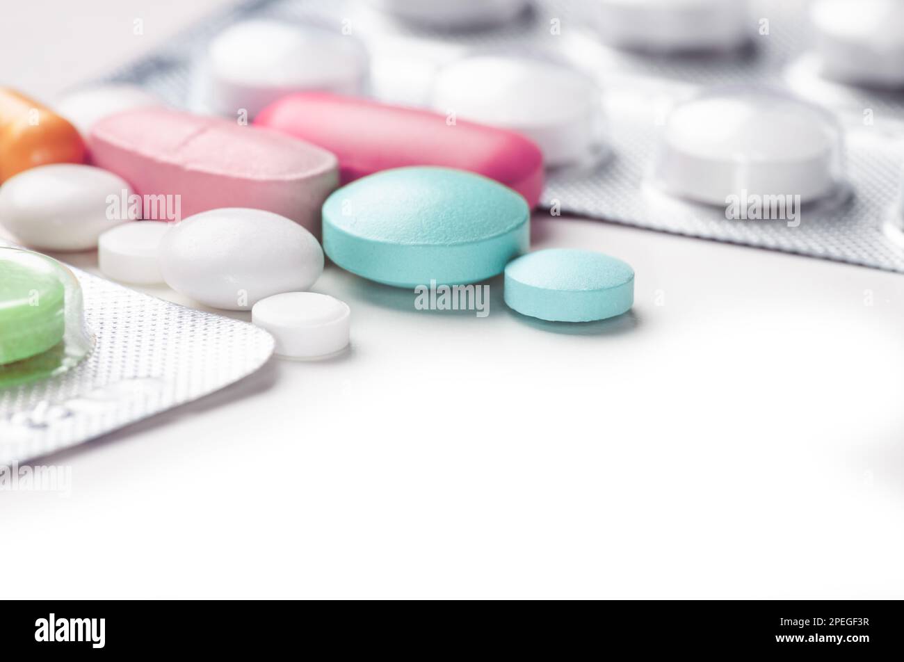 Spilled blu bianco rosa verde pillole da prescrizione aperta farmaco sfondo grigio Foto Stock