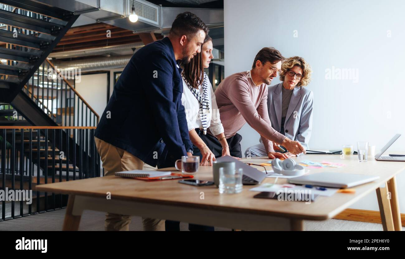 Team di professionisti che discutono idee aziendali in un'agenzia di marketing. Gruppo di uomini d'affari che fanno brainstorming in una riunione. i professionisti del settore Foto Stock