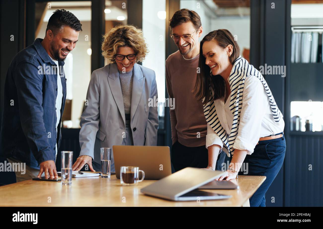 Team aziendale di successo che si connette con i propri clienti durante una videochiamata. Gente felice di affari che ha una riunione in linea in un ufficio. Networking e co Foto Stock