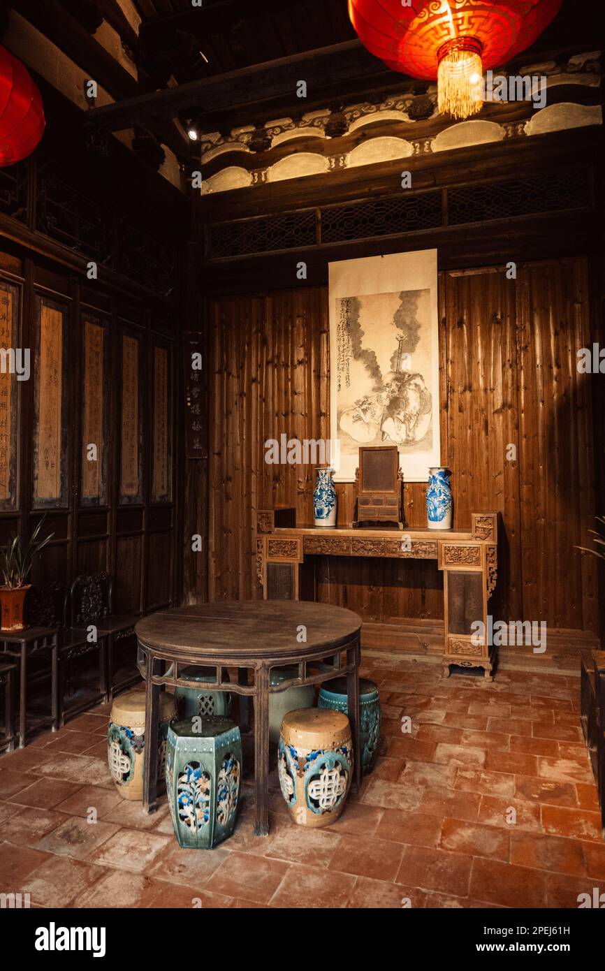 Interni tradizionali della casa da tè cinese con mobili in legno, set da tè e rotoli cinesi Foto Stock