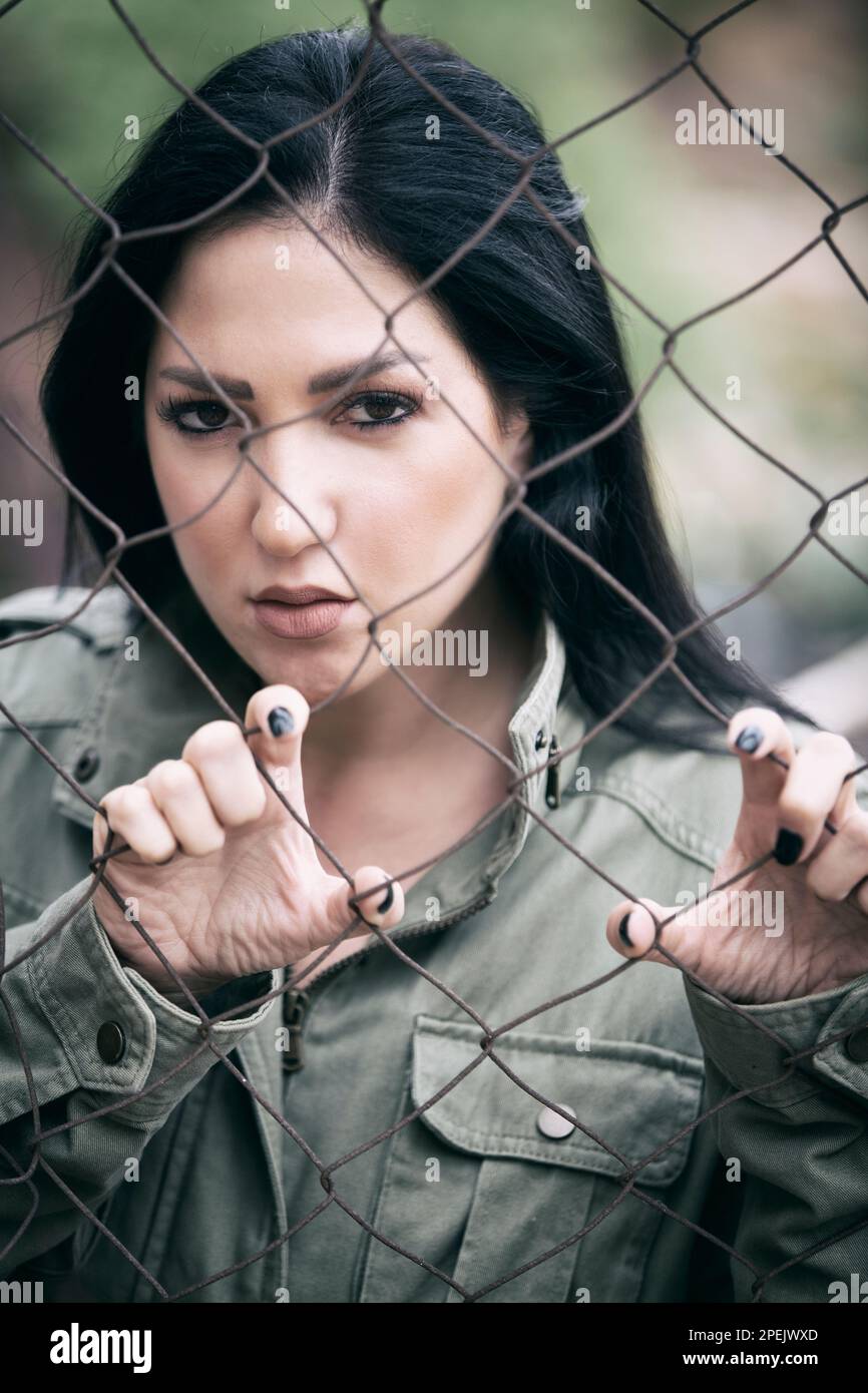 Donna seria che tiene recinto filo di pollo Foto Stock