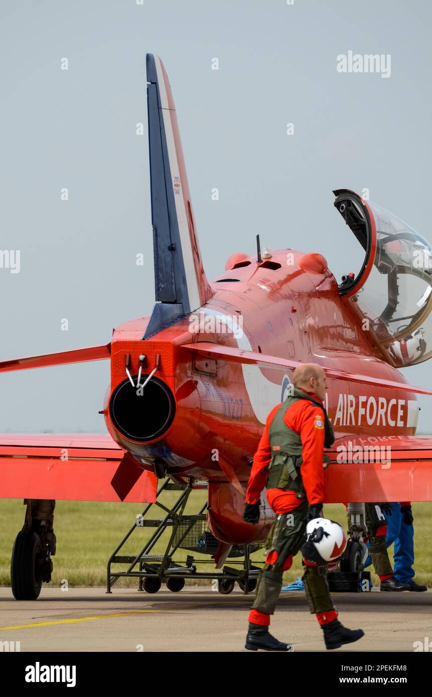 Royal Air Force Red Arrows mostra il pilota della squadra (sfocato) che cammina verso il jet plane BAe Hawk T1 prima dell'esposizione, RAF Scampton. Tubi di fumo sullo scarico Foto Stock