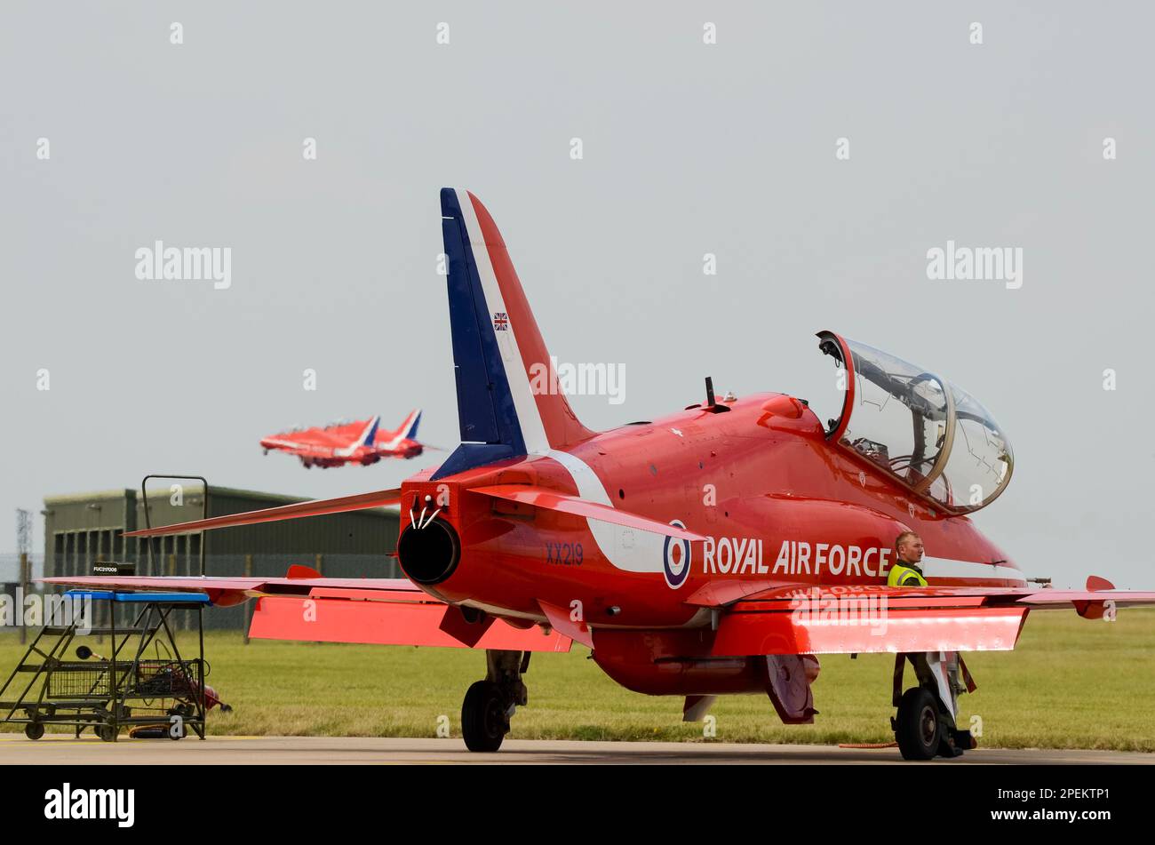 Royal Air Force Red Arrows mostra il team BAe Hawk T1 jet plane che decolgono per esporre al RAF Scampton, sopra jet di ricambio e ingegnere dell'equipaggio di terra Foto Stock