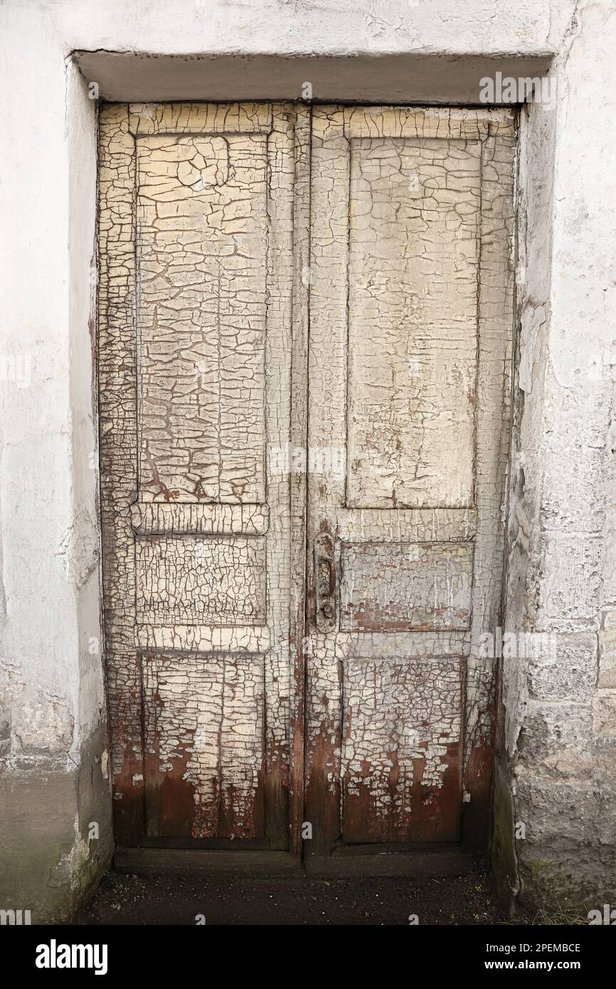 Vecchia porta anteriore in legno intemperiata con vernice di distacco Foto Stock