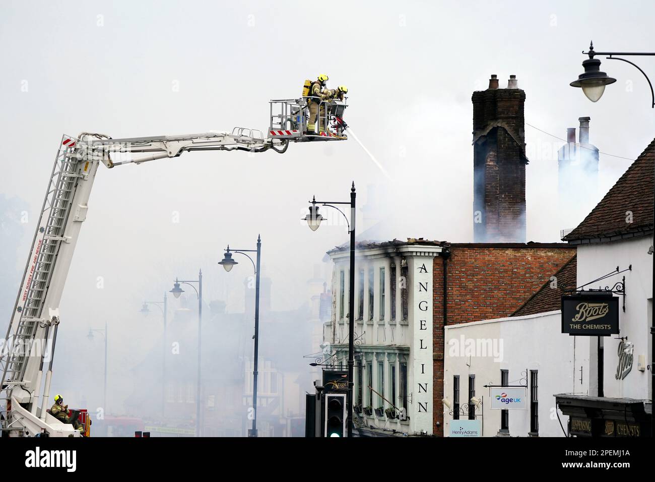 Vigili del fuoco che si trovano a Midhurst, nel Sussex occidentale, e che comprende un hotel di 400 anni che si dice ospitasse rifugiati ucraini. Si pensava che l'incendio fosse scoppiato poco dopo le 1am di giovedì in una proprietà di North Street prima di diffondersi sul tetto dell'Angel Inn accanto. Data immagine: Giovedì 16 marzo 2023. Foto Stock