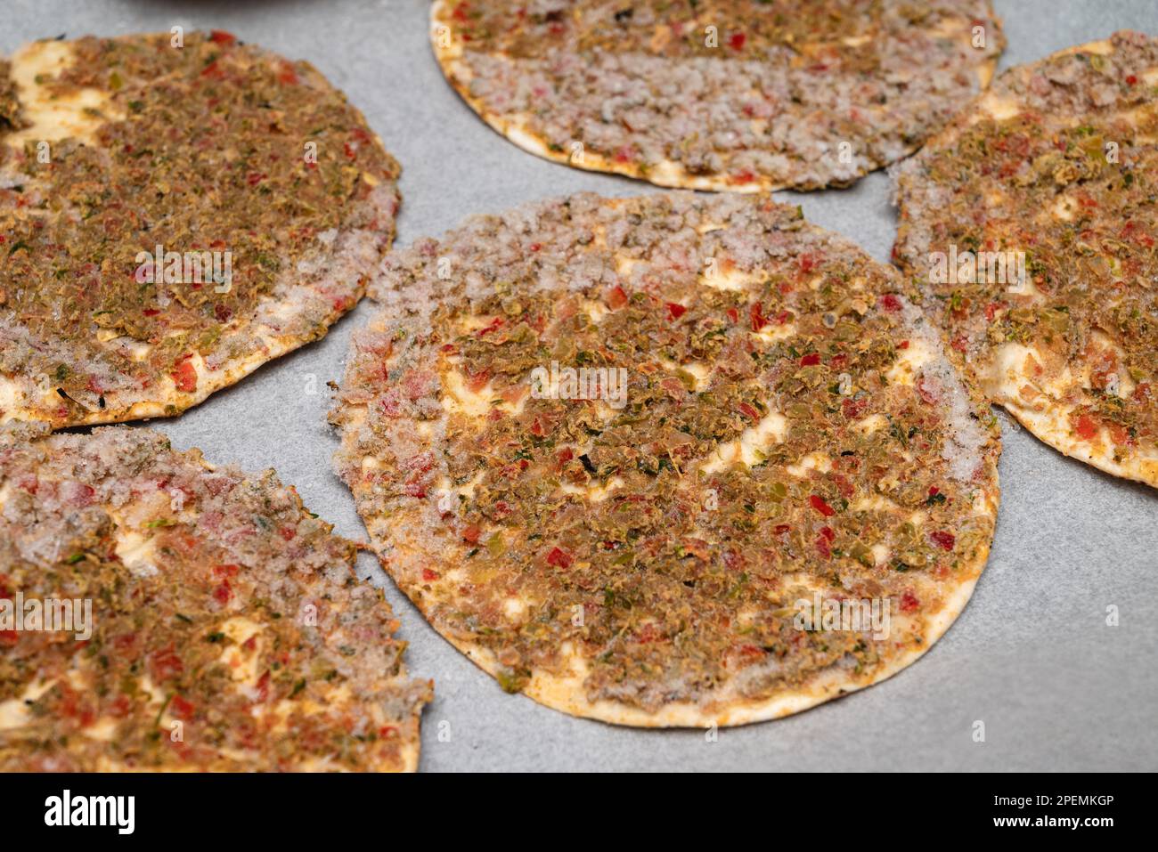 un lahmacun surgelato pronto da mangiare su carta da forno su una teglia da forno Foto Stock