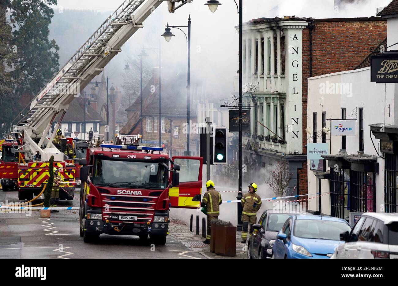 Vigili del fuoco che si trovano a Midhurst, nel Sussex occidentale, e che comprende un hotel di 400 anni che si dice ospitasse rifugiati ucraini. Si pensava che l'incendio fosse scoppiato poco dopo le 1am di giovedì in una proprietà di North Street prima di diffondersi sul tetto dell'Angel Inn accanto. Data immagine: Giovedì 16 marzo 2023. Foto Stock
