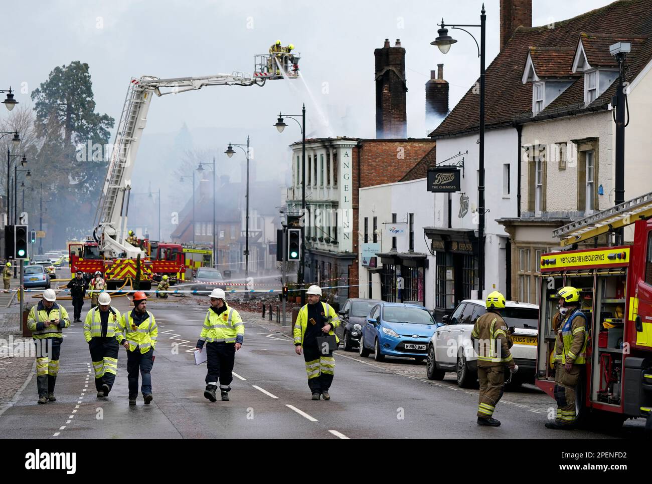 Vigili del fuoco che si trovano a Midhurst, nel Sussex occidentale, e che comprende un hotel di 400 anni che si dice ospitasse rifugiati ucraini. Si pensava che l'incendio fosse scoppiato poco dopo le 1am di giovedì in una proprietà di North Street prima di diffondersi sul tetto dell'Angel Inn accanto. Data immagine: Giovedì 16 marzo 2023. Foto Stock