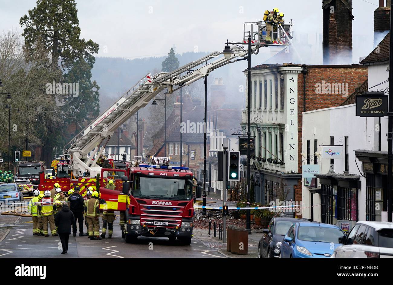 Vigili del fuoco che si trovano a Midhurst, nel Sussex occidentale, e che comprende un hotel di 400 anni che si dice ospitasse rifugiati ucraini. Si pensava che l'incendio fosse scoppiato poco dopo le 1am di giovedì in una proprietà di North Street prima di diffondersi sul tetto dell'Angel Inn accanto. Data immagine: Giovedì 16 marzo 2023. Foto Stock