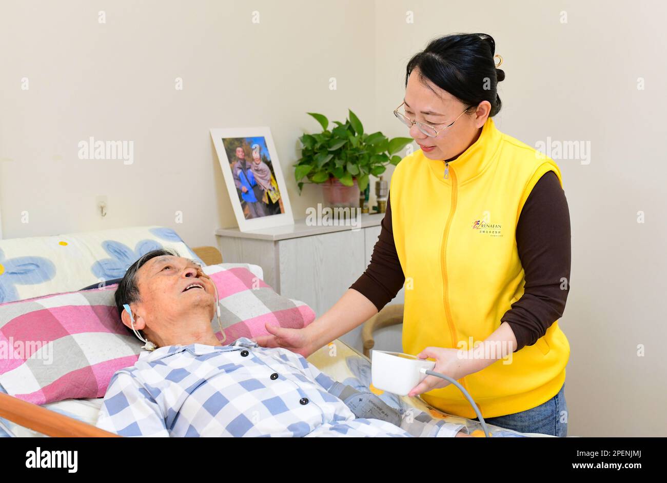 HOHHOT, CINA - 16 MARZO 2023 - Un volontario fornisce servizi sanitari a una persona anziana in un complesso di servizi di assistenza agli anziani della comunità di Hohhot, Inne Foto Stock