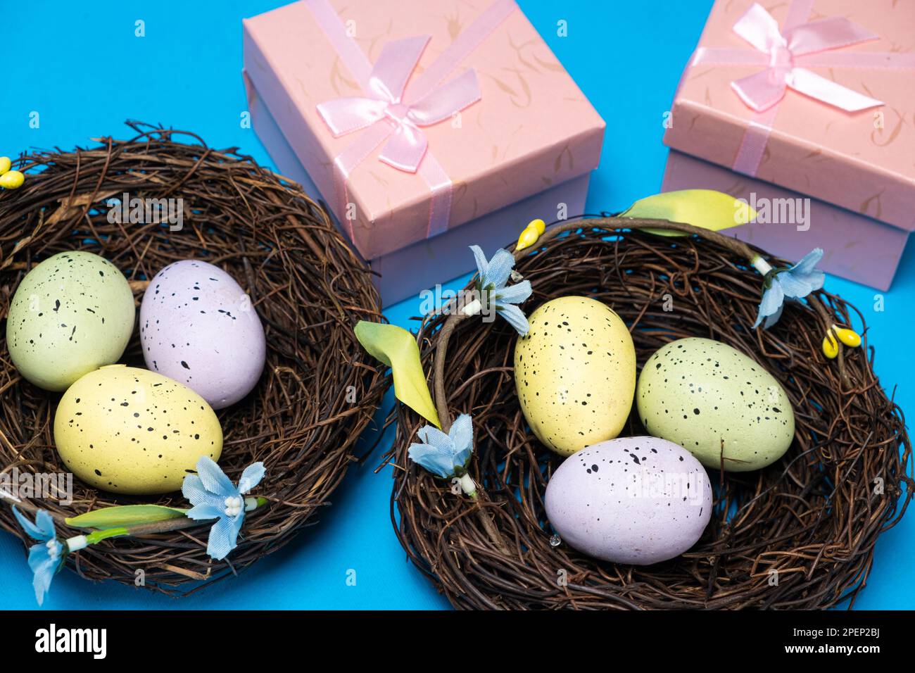 Regali per Pasqua, promozione di Pasqua. Uova in nidi e scatole regalo su sfondo blu. Foto Stock
