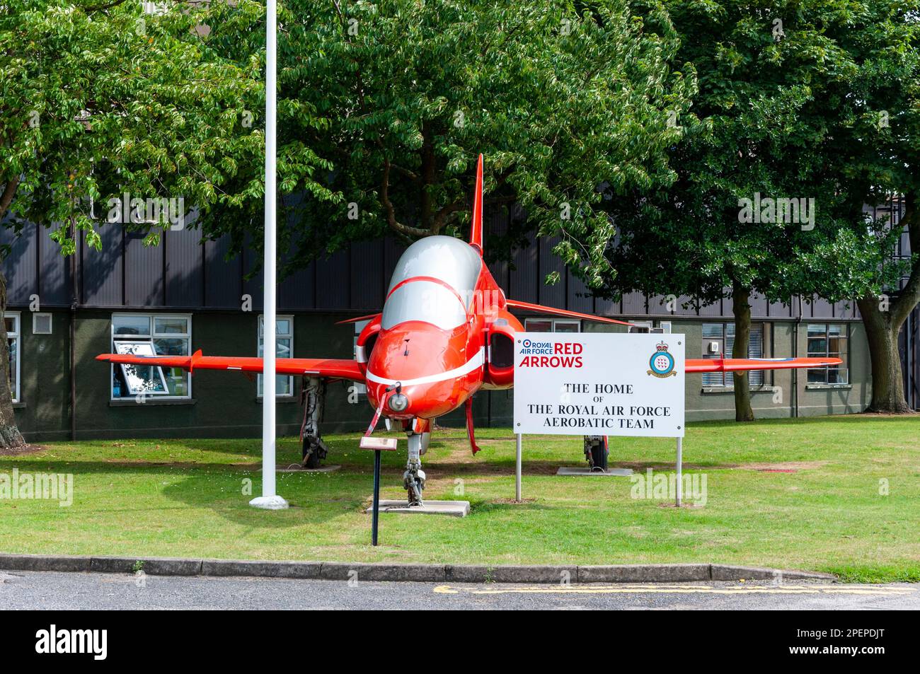 Royal Air Force, RAF Red Arrows mostra il team BAe Hawk T1 jet plane in mostra al RAF Scampton, Lincolnshire, Regno Unito. Hangar e segno di squadra Foto Stock