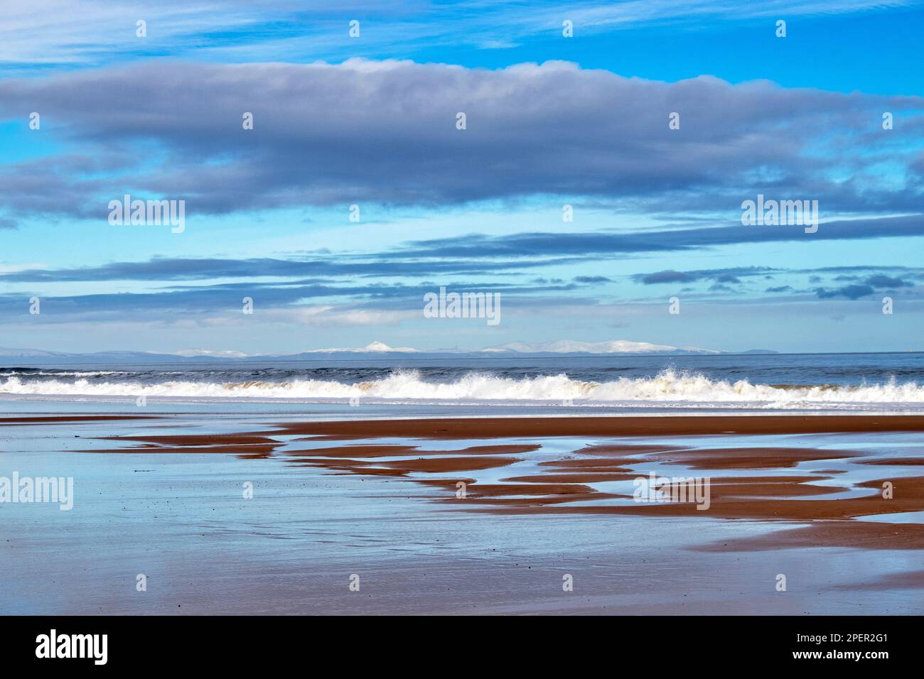 Lossiemouth Moray Coast Scotland guardando su East Beach sabbie alle colline coperte di neve di Sutherland Foto Stock