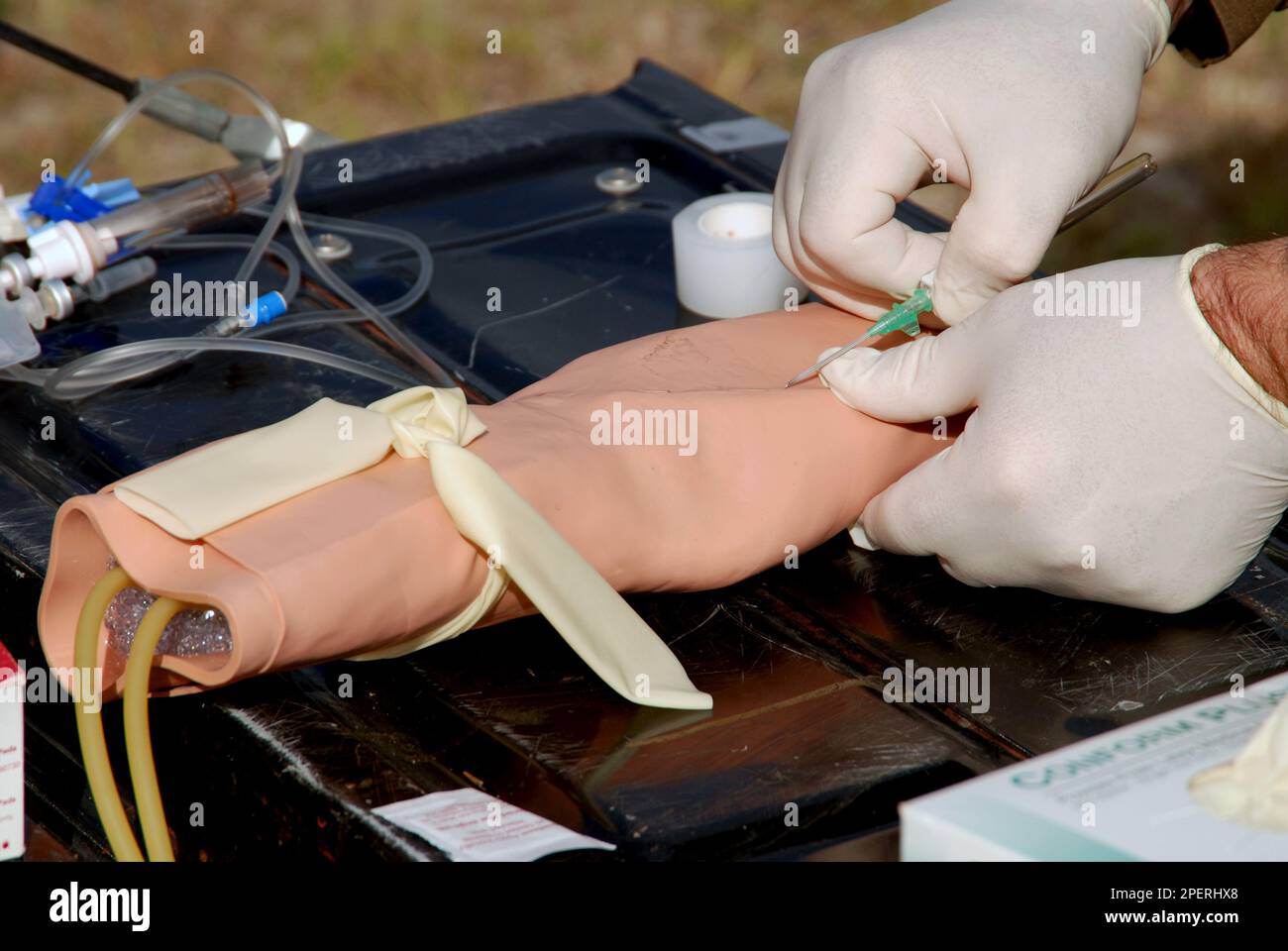 Un medico che pratica l'inserimento di un catetere IV Foto Stock