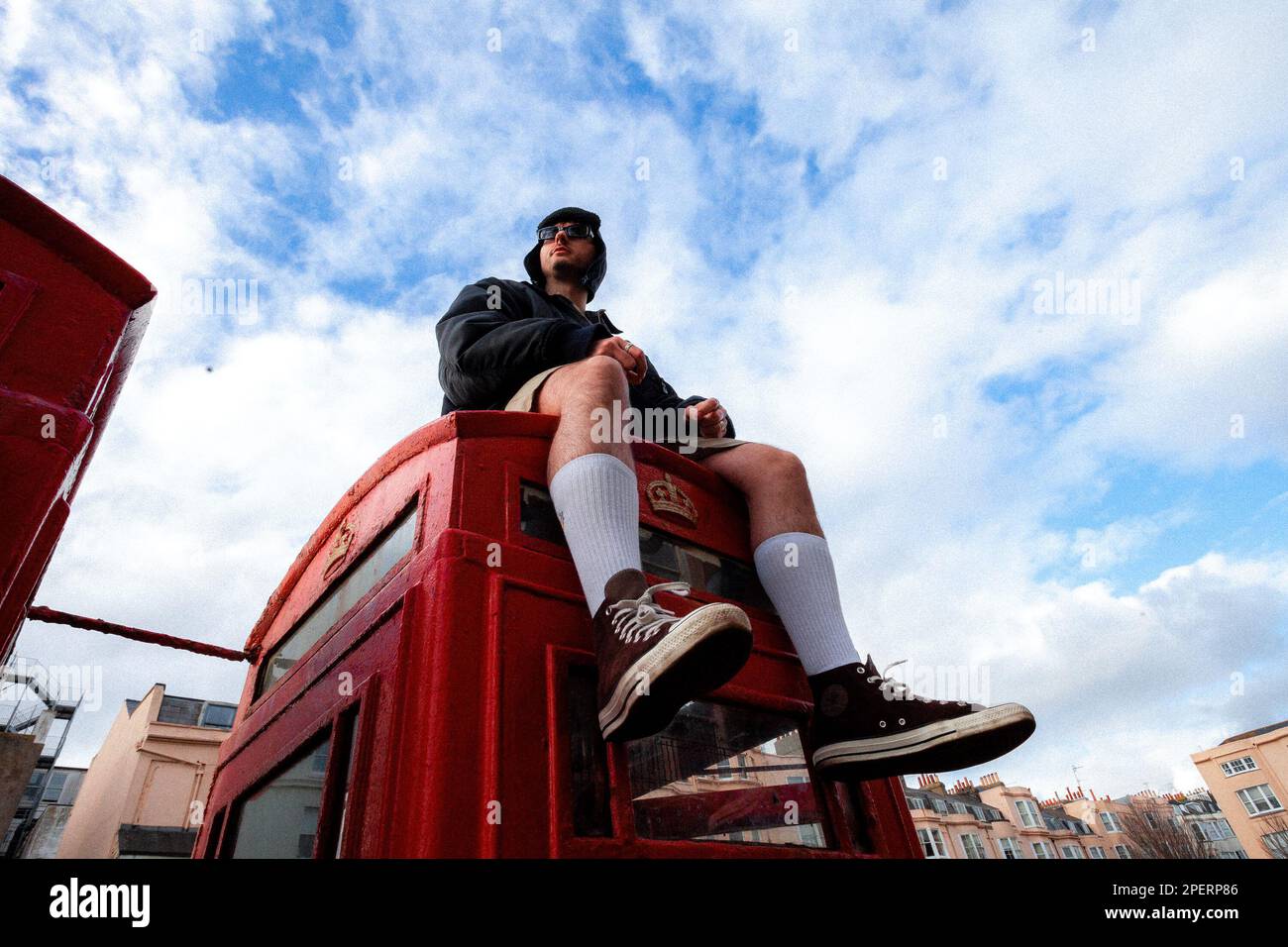 Giovane uomo in una scatola telefonica britannica - Brighton & Hove, East Sussex, UK Foto Stock
