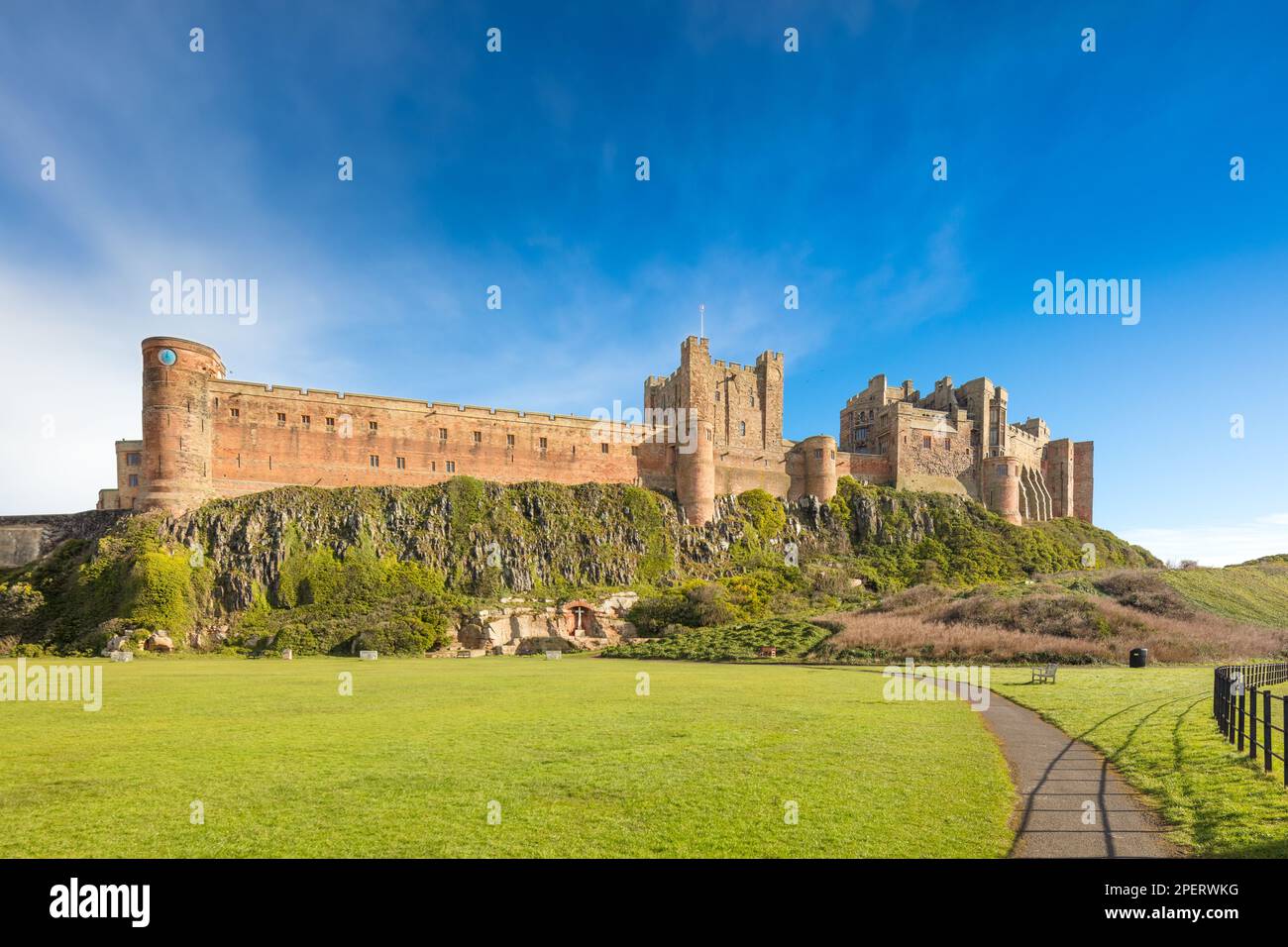 Castello di Bamburgh Vista Sud Ovest dalla strada B1340 a sud del villaggio di Bamburgh. mostra parte del campo di cricket in primo piano. Foto Stock