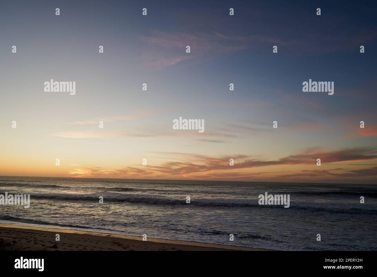 Un bel tramonto in spiaggia con colori e contrasto piacevoli Foto Stock