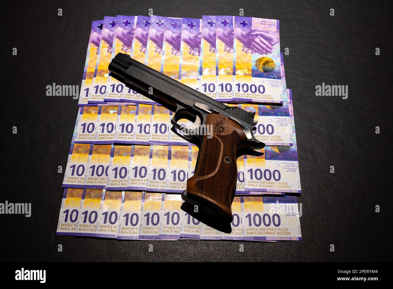 Elegante pistola semiautomatica 9mm con Swiss Helvetia Symbol appoggiata sulla banconota da 1000 franchi svizzeri. Foto Stock