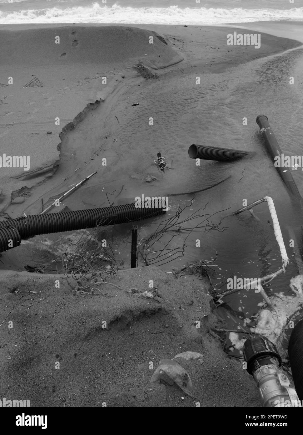 Acque reflue industriali, la conduttura scarica i rifiuti industriali liquidi in mare su una spiaggia cittadina. Le acque reflue sporche scorrono da un tubo fognario in plastica su Foto Stock