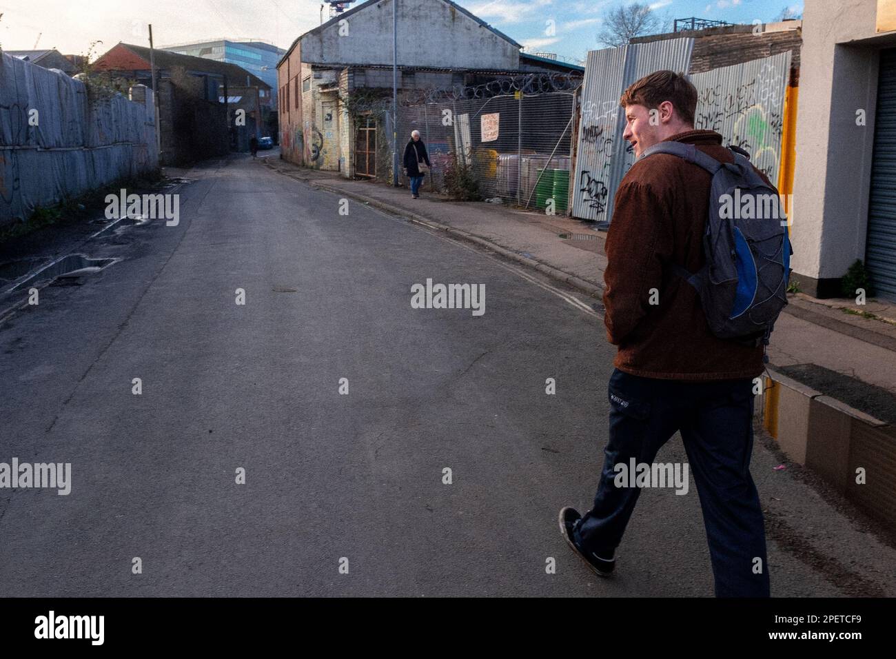 Giovane uomo cammina lungo la strada industriale - gas Lane, Bristol, Somerset, Regno Unito Foto Stock