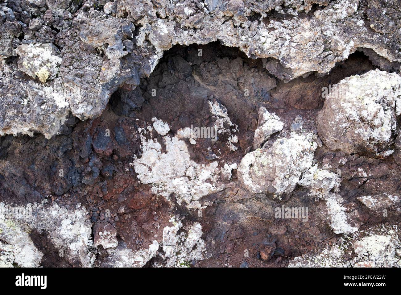 Rocce rosse e nere nella parte di raffreddamento del gap di ventilazione coperta in lichene nella sezione trasversale del flusso lavico parque nacional de timanfaya Lanzarote, Isole Canarie, SPAI Foto Stock
