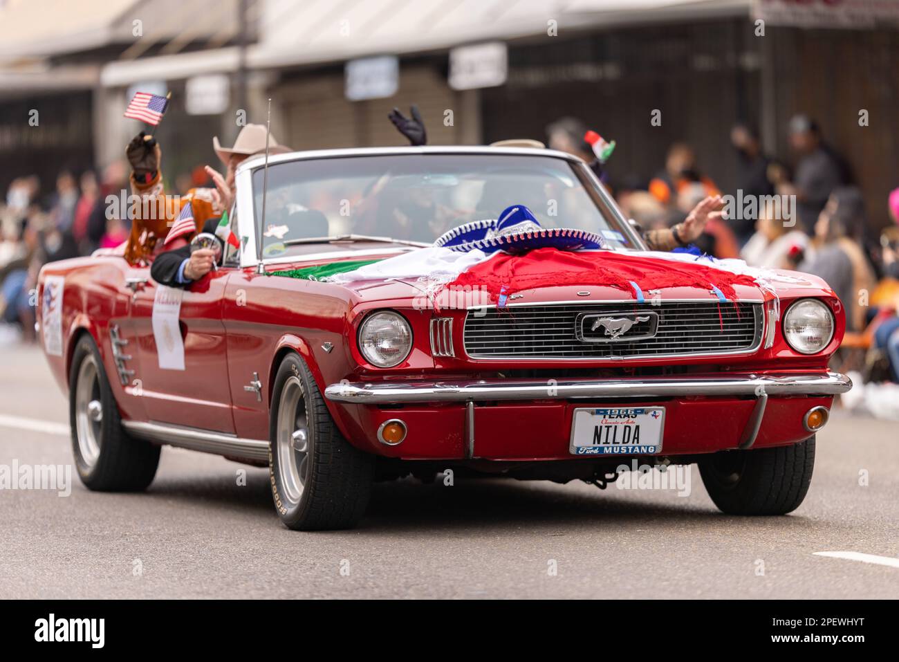 Brownsville, Texas, USA - 26 febbraio 2022: Charro Days Grand International Parade, Ford Mustang auto classica, decorata con la bandiera messicana e un c Foto Stock