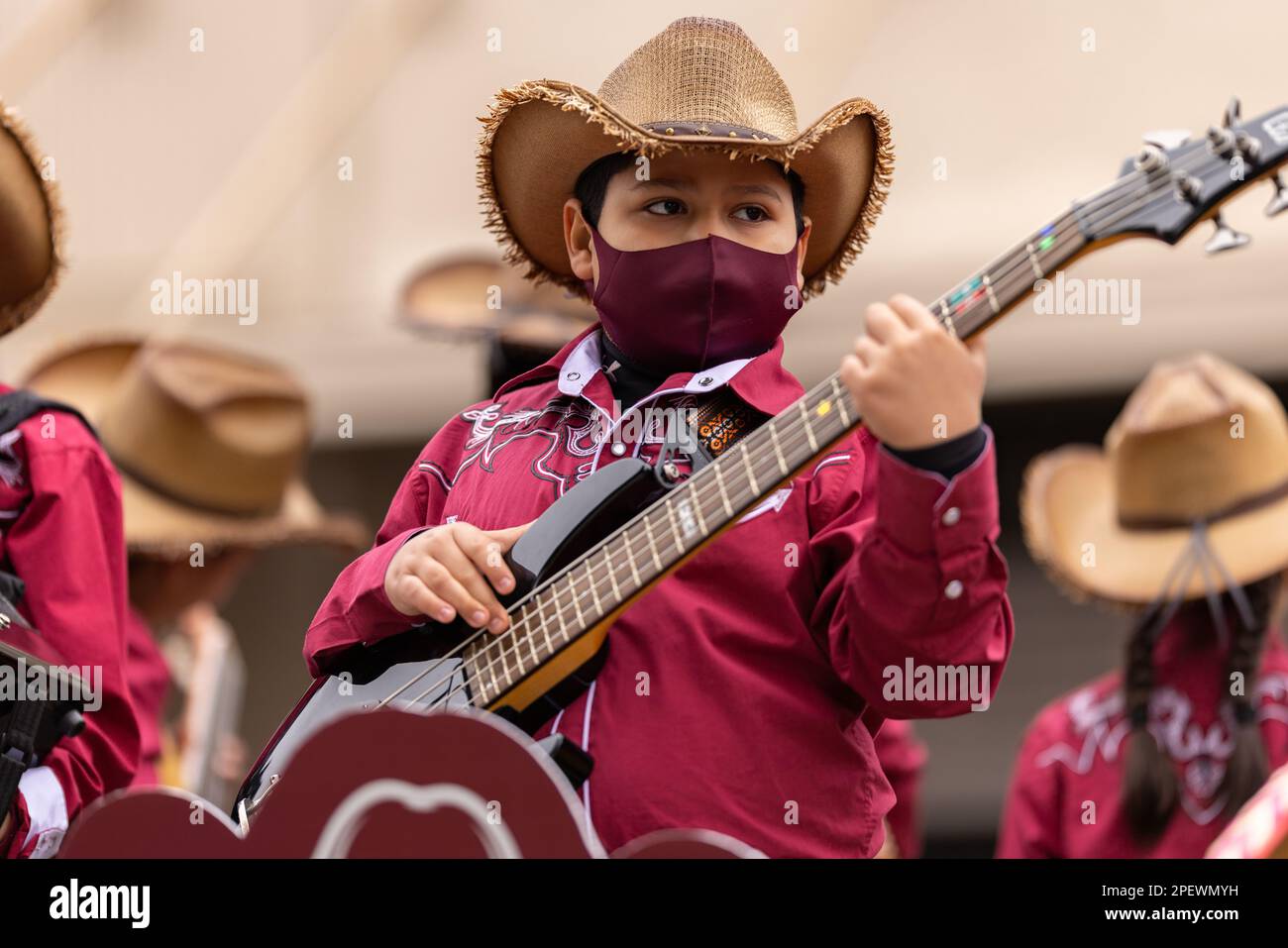 Brownsville, Texas, USA - 26 febbraio 2022: Charro Days Grand International Parade, ragazzo vestire come cowboy, suonare la chitarra alla parata Foto Stock