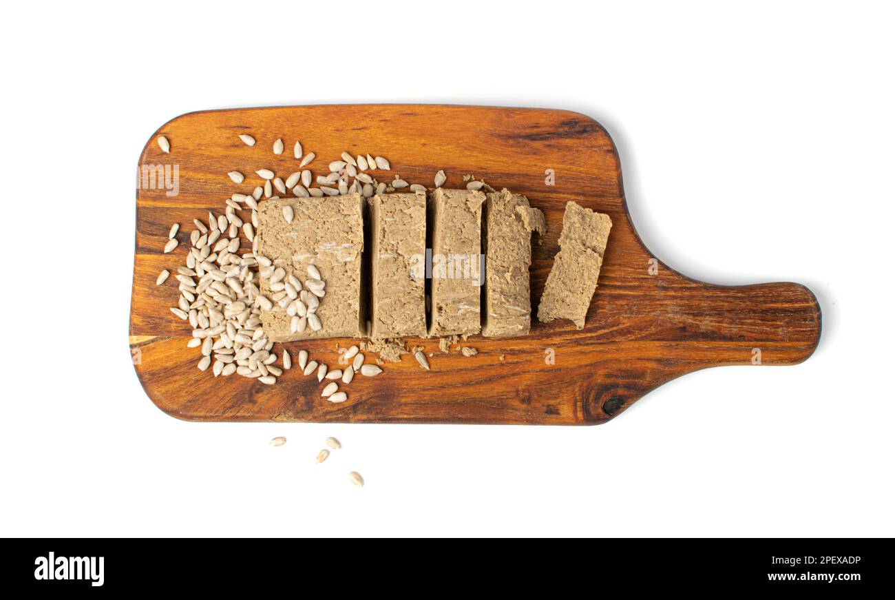 Pezzi halva su legno tagliere isolato, Sunflower Halawa, Halvah o Halwa su sfondo bianco Vista dall'alto Foto Stock