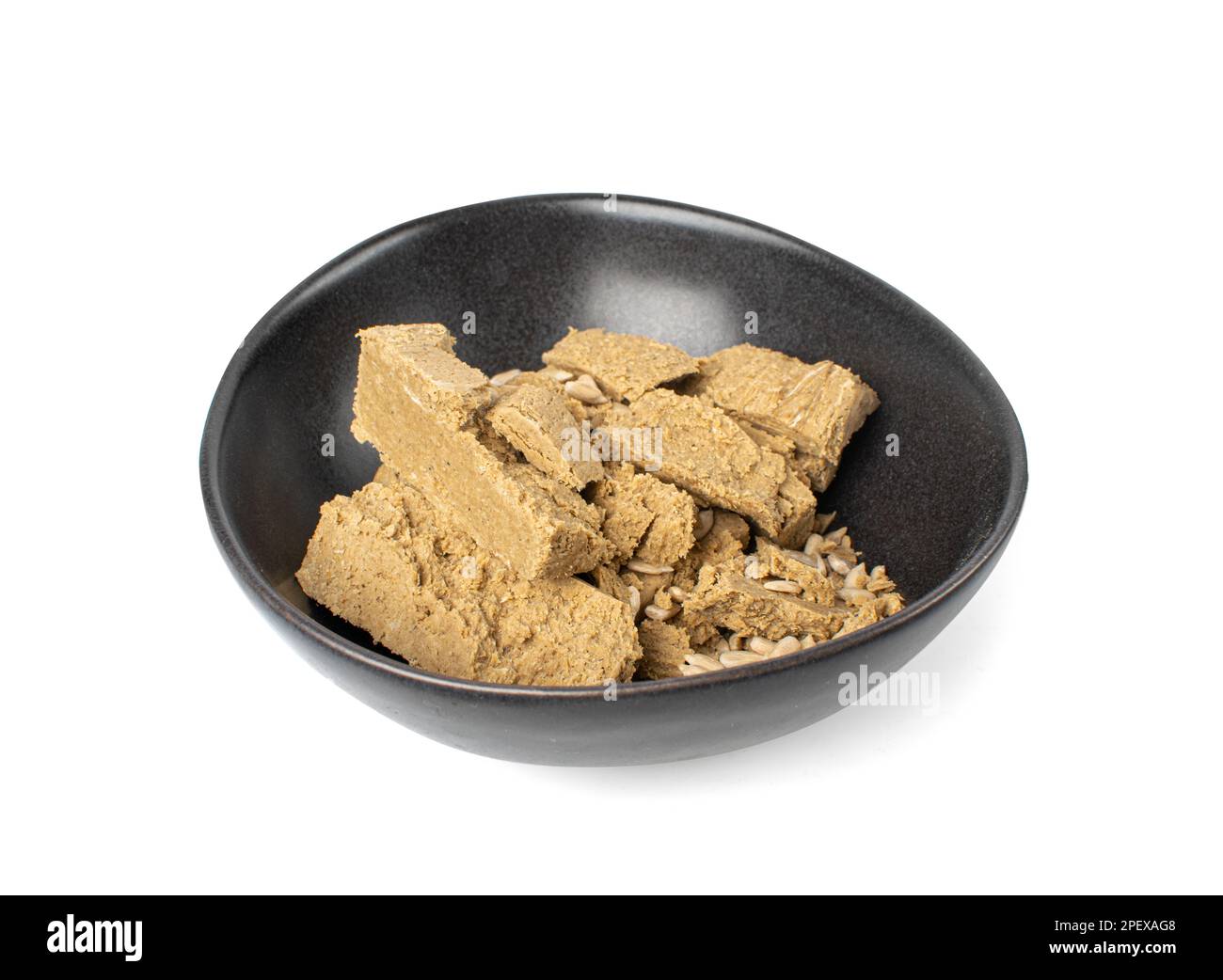Pezzi di halva in ciotola nera isolata, Sunflower Halawa, Halvah o Halwa su sfondo bianco, Clipping Path Foto Stock