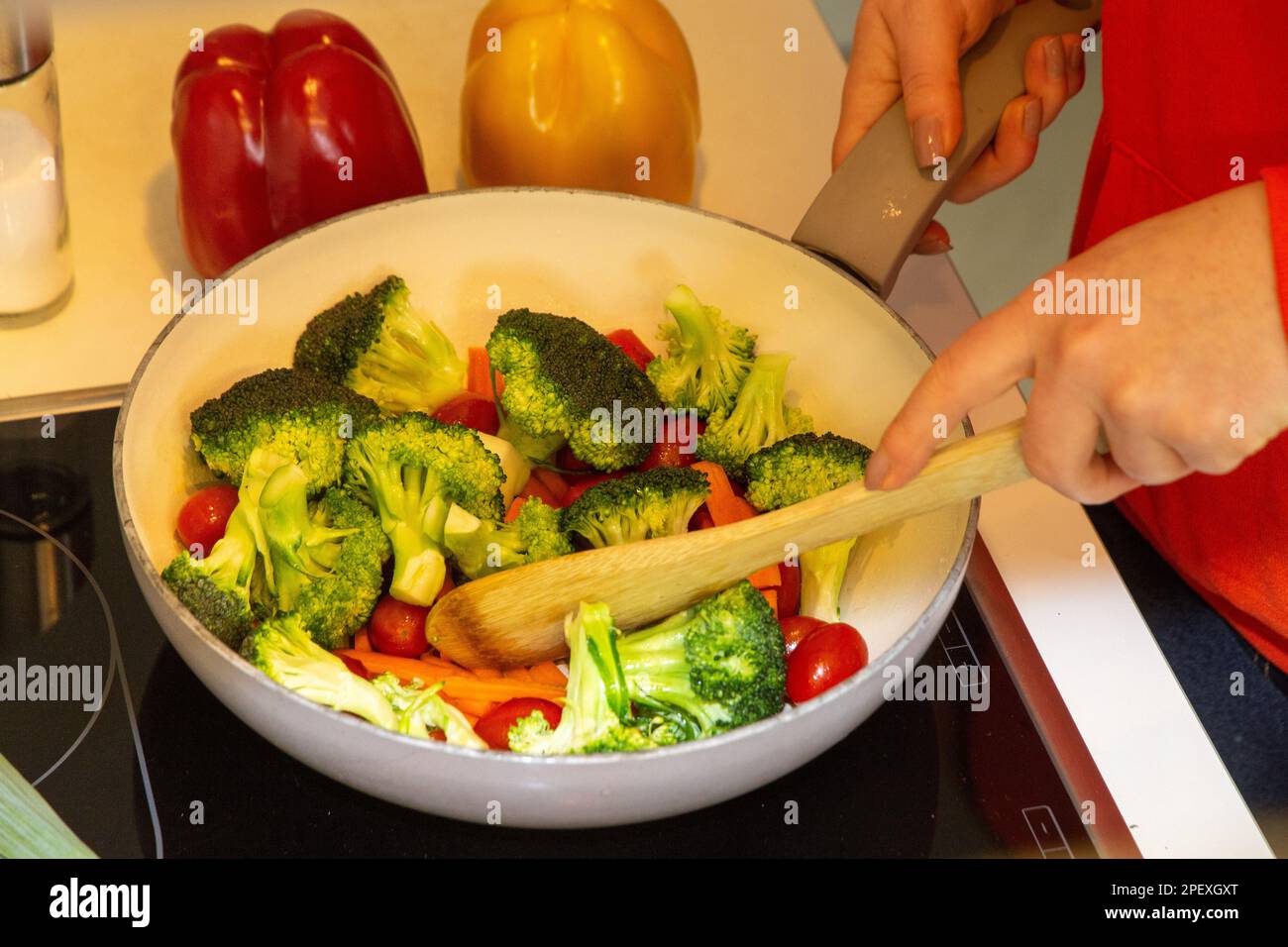 Cottura vegana: Primo piano di una padella con broccoli, carote e pomodori da cocktail Foto Stock