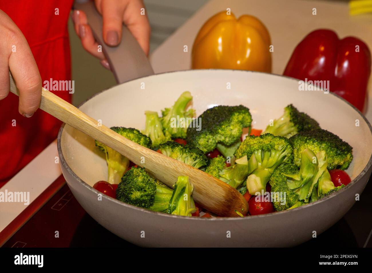 Cottura vegana: Primo piano di una padella con broccoli, carote e pomodori da cocktail Foto Stock