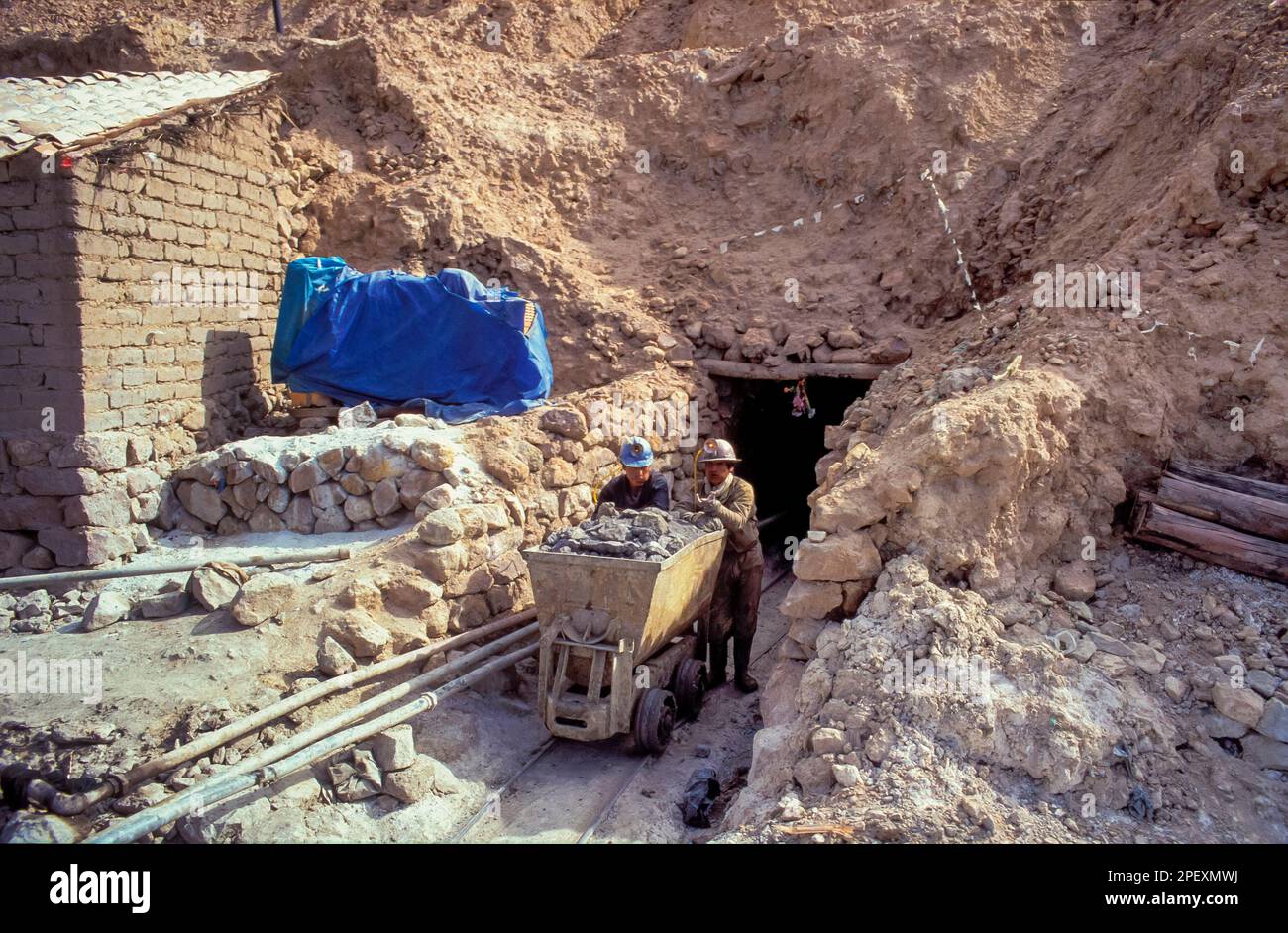 Bolivia, Potosi. I dipendenti stanno spingendo un camion fuori dalla miniera d'argento e in parte di stagno. Foto Stock