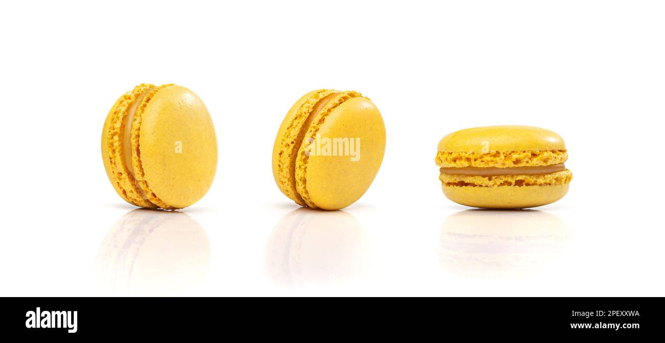 Torta di macaron gialla isolata, cookie di macarone al limone, meringa alle mandorle, amaretti dolci, dessert francese colorato su sfondo bianco Foto Stock