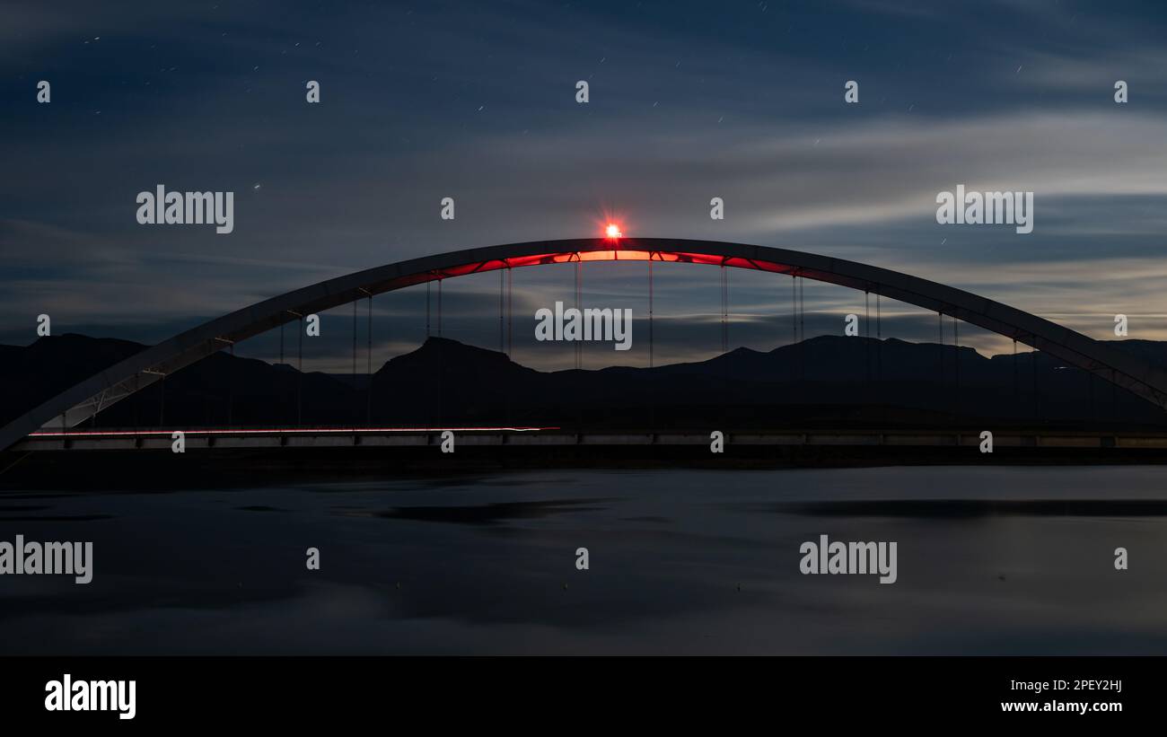 Una bella scena notturna del Theodore Roosevelt Lake Bridge illuminata da una luce brillante Foto Stock