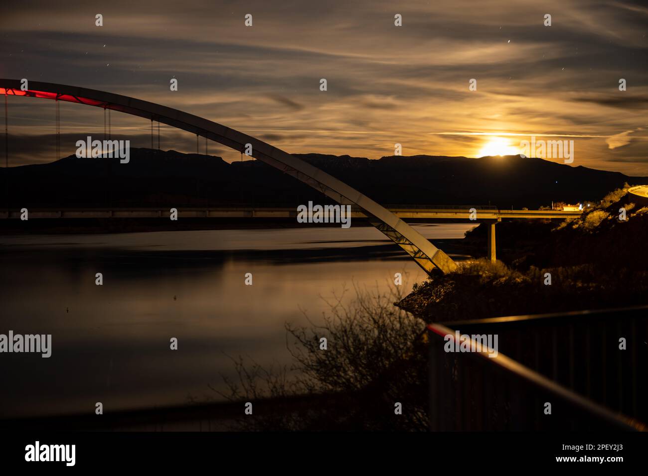 Una bella scena notturna del Theodore Roosevelt Lake Bridge illuminata da una luce brillante Foto Stock
