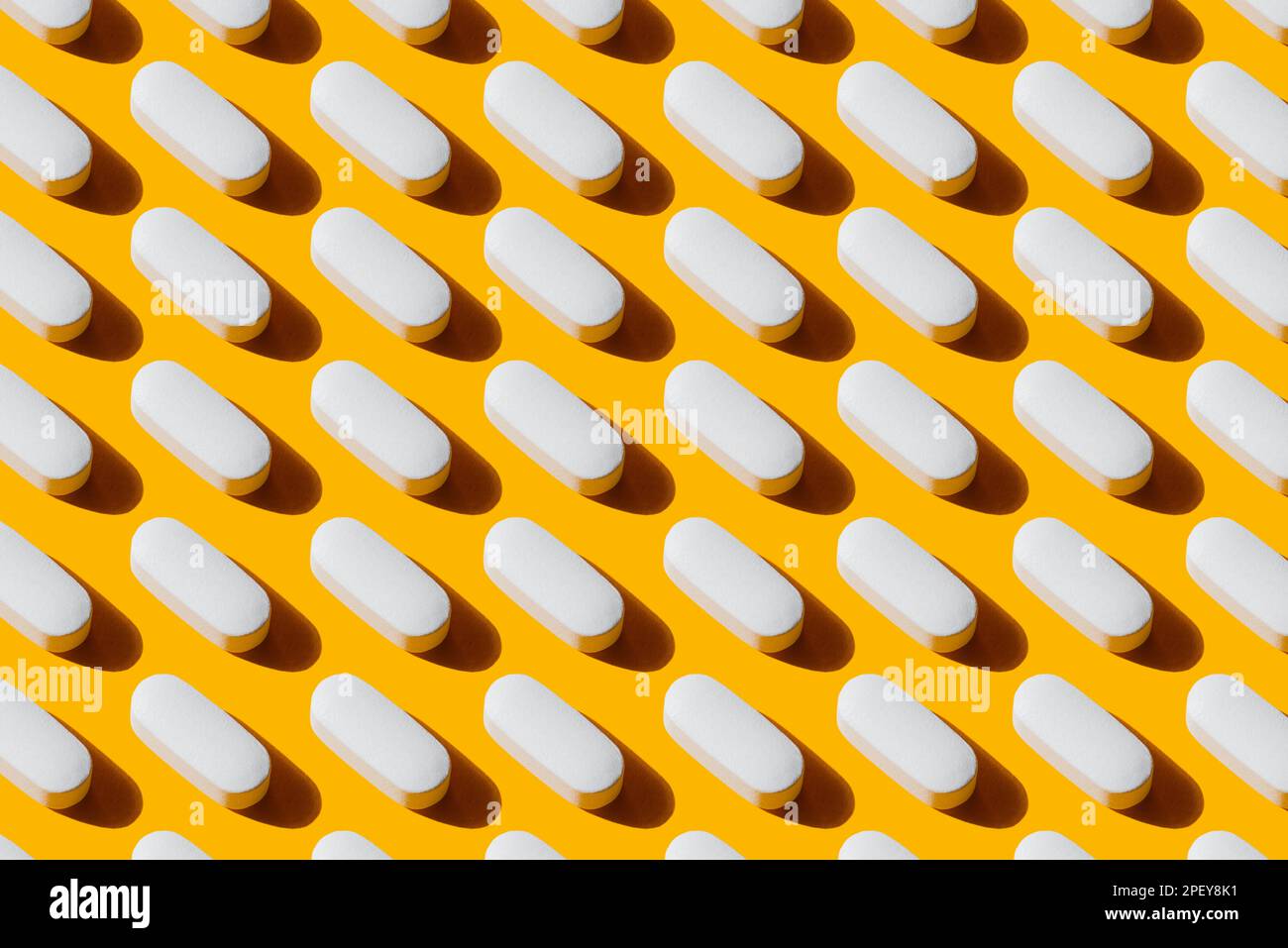 Pop Art Pattern Vitamina in pillole bianche capsula di calcio isolato su sfondo giallo, prendendo integratori alimentari e vitamine Foto Stock