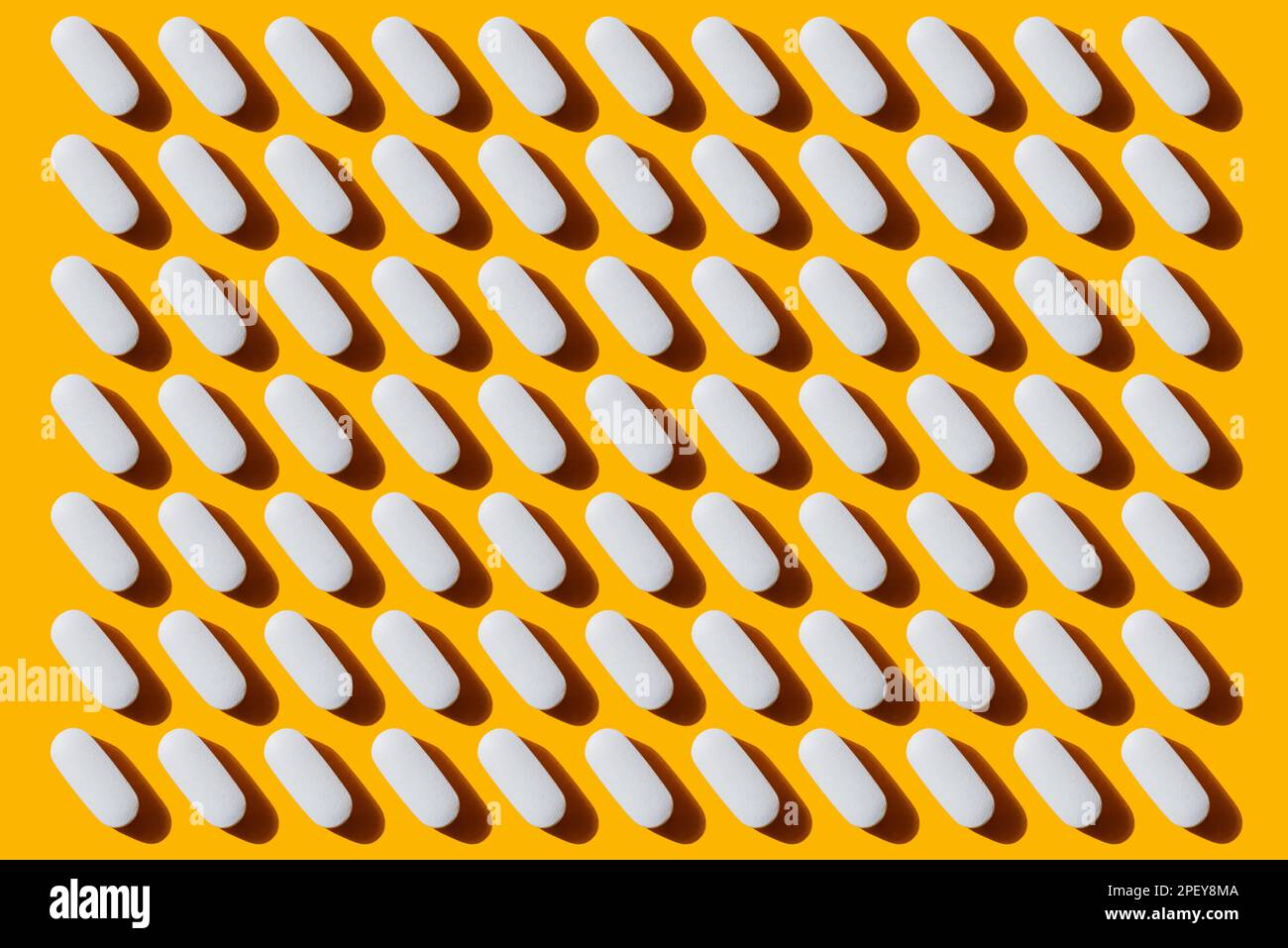 Pop Art Pattern Vitamina in pillole bianche capsula di calcio isolato su sfondo giallo, prendendo integratori alimentari e vitamine Foto Stock