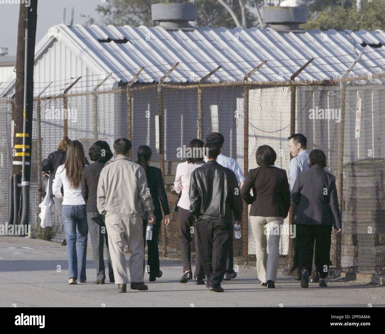 Thi Dinh Bui, family members and friends enter an immigration court in Los Angeles' San Pedro harbor district Tuesday, April 27, 2004. At this hearing Bui was to be offered a chance to defend himself against deportation for torturing prisoners at a re-education camp in postwar Vietnam and causing at least two deaths. A judge will then decide whether he should be removed, lose his work permit or face other penalties. (AP Photo/Nick Ut) Foto Stock
