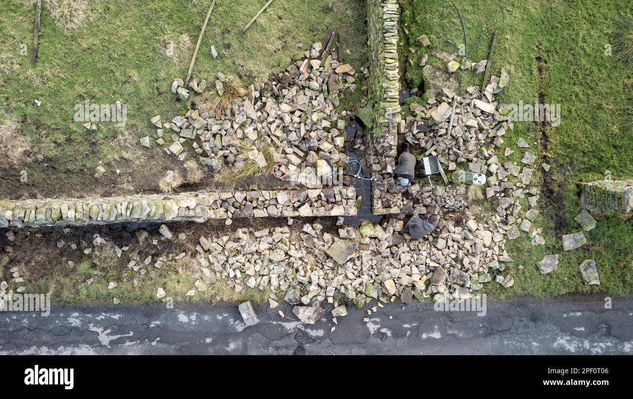muri a secco che ricostruiscono un muro come parte di un progetto ambientale governativo su una fattoria in collina nel Yorkshire Dales, Regno Unito. Foto Stock
