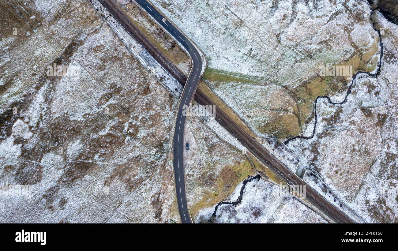 Strada rurale sulla brughiera che attraversa il Settle per Carlisle Railway alla cima di Aisgill, Mallerstang, Cumbria, Regno Unito. Foto Stock