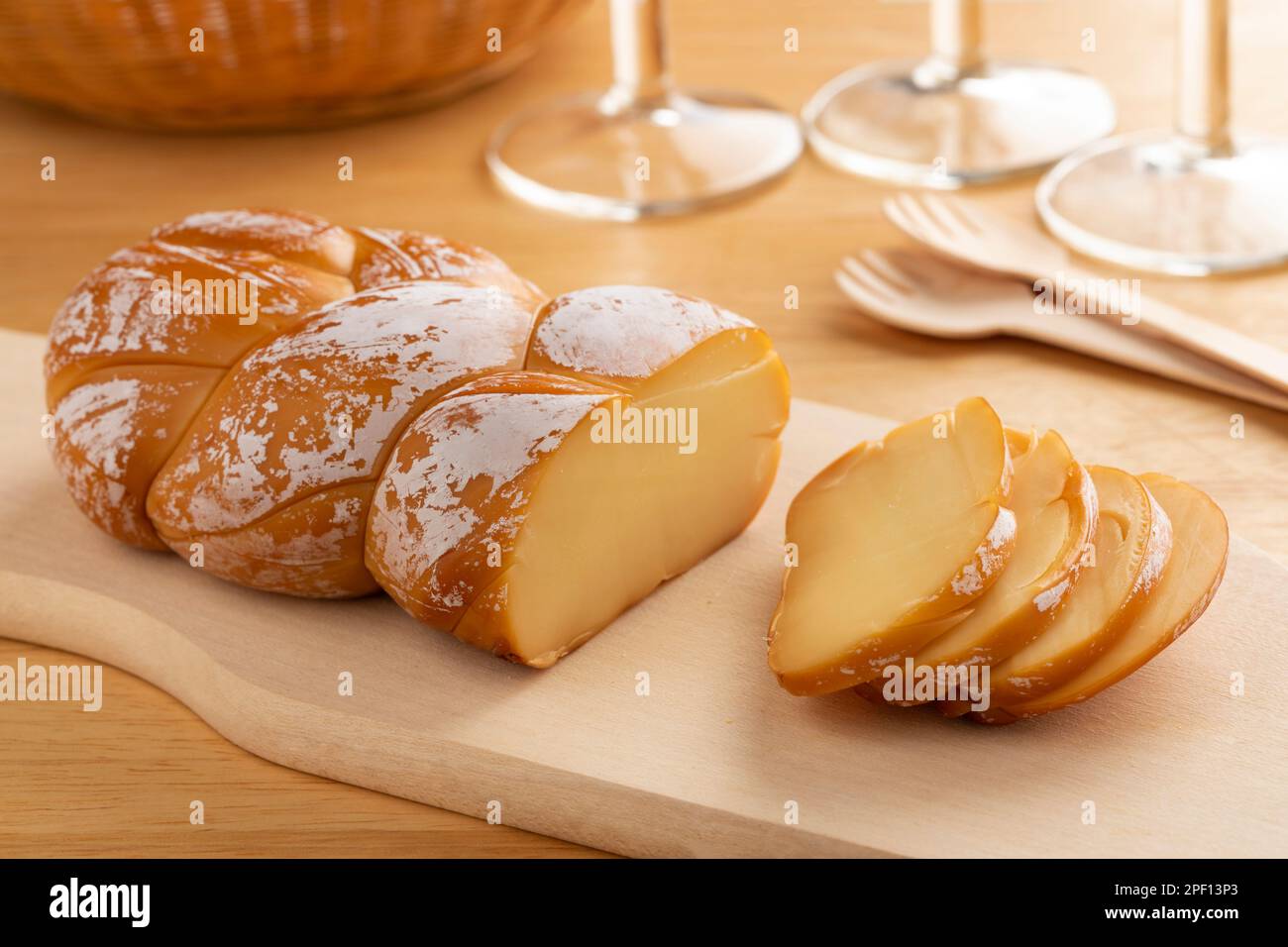 Tradizionale formaggio affumicato ritorto rumeno, Cascaval afumat impletit, in primo piano su un tagliere Foto Stock