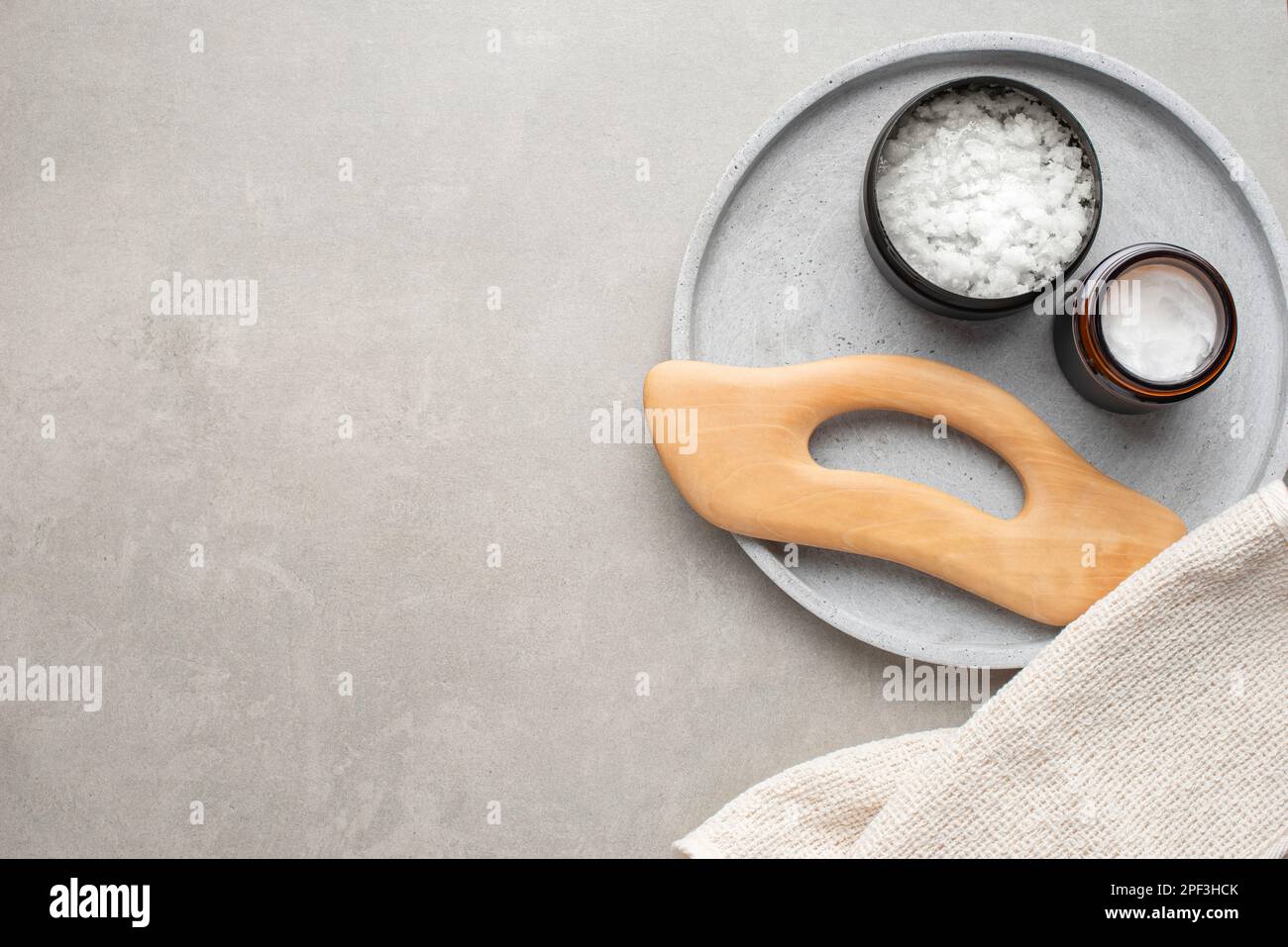 background con prodotti cosmetici per la cura del corpo. Bagno grigio. Mezzi per il massaggio. Foto Stock