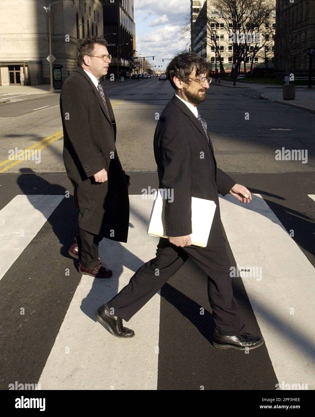 Martin D. Gelfand, right, senior counsel to Rep. Dennis Kucinich, D-Ohio, walks to federal bankruptcy court to file papers Monday, Dec. 1, 2003, in Cleveland, accompanied by Joseph Scott, left, chief assistant director of law for the city of Cleveland. Mayor Jane Campbell and Kucinich said Monday they will ask a bankruptcy court for an order to open Deaconess Hospital, a small community hospital that suddenly shut down Friday night without notice. (AP Photo/Tony Dejak) Foto Stock