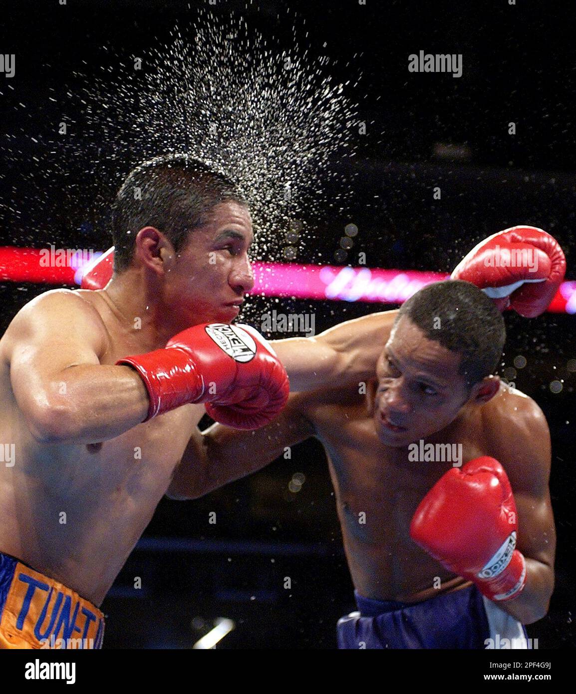 Daniel Reyes of Colombia, right, hits Edgar Cardenas of Mexico during their IBF light flyweight title bout, Saturday night, Oct. 4, 2003, in Los Angeles. Reyes knocked out Cardenas in the sixth round. (AP Photo/Mark J. Terrill) Foto Stock