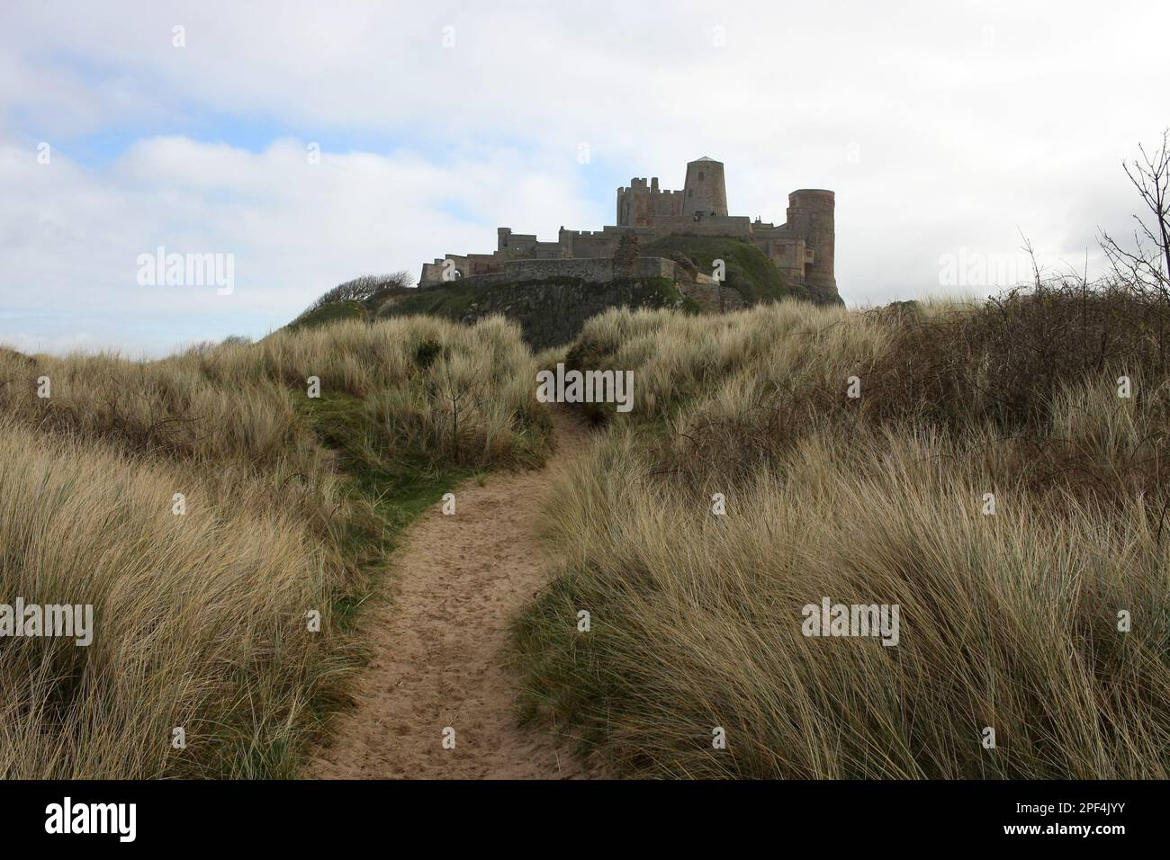 Bamburgh Beach sotto il Castello, l'imponente castello medievale e situato all'interno della Northumberland Coast Area di straordinaria bellezza Foto Stock